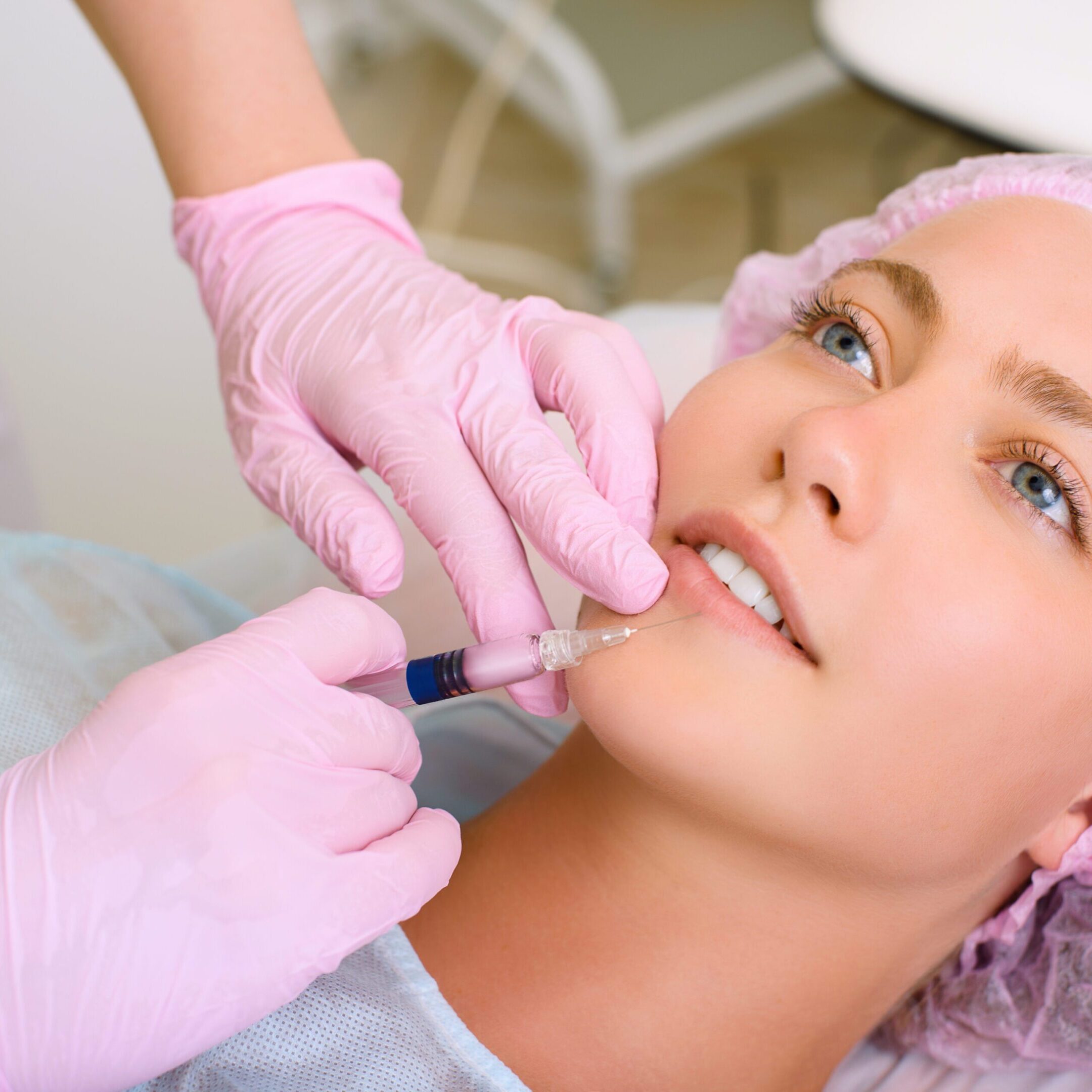 Image of a young beautiful woman dressed as a patient lying on a couch in a cosmetology clinic during a procedure. Contour correction, botulinum therapy, revitalization, rejuvenation, skin treatment.