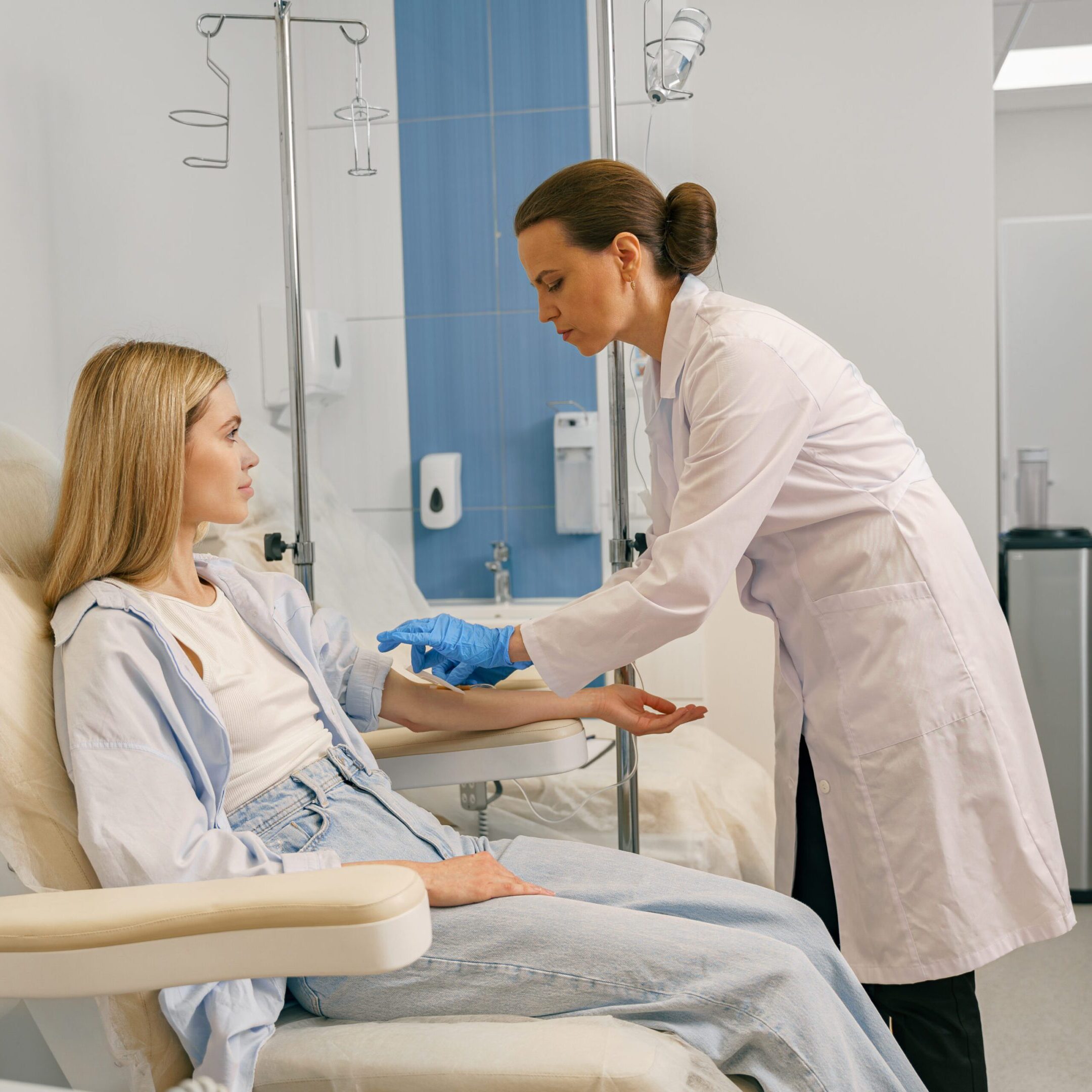 Professional doctor putting an IV drip to patient intravenously in hospital. High quality photo